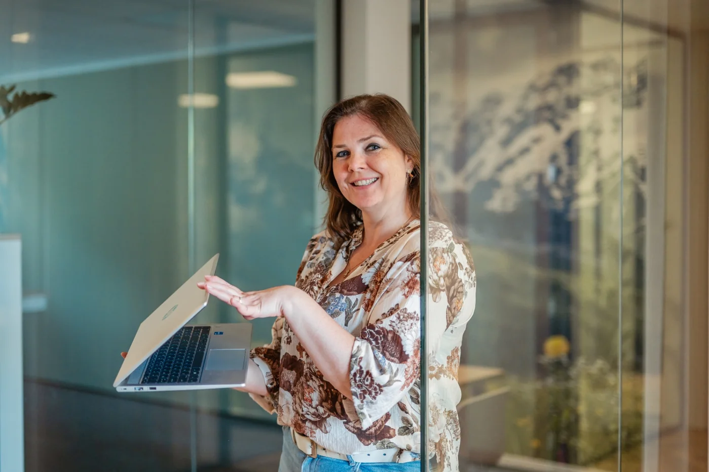 Adviseur van PoortEijk met laptop bij glazen wand op kantoor in Leusden