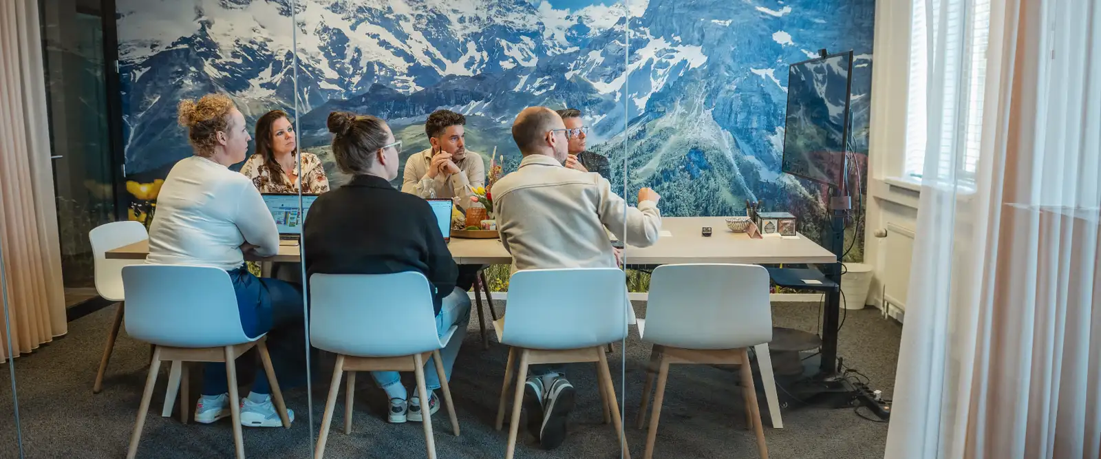 Collega's van PoortEijk overleggen aan tafel in de vergaderruimte op kantoor in Leusden